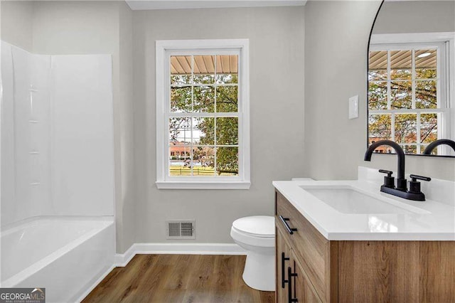 full bathroom featuring hardwood / wood-style flooring, vanity, toilet, and shower / bathing tub combination