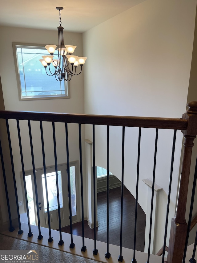 stairs with a chandelier