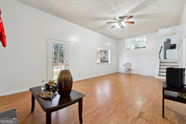 living room with ceiling fan, a textured ceiling, and hardwood / wood-style flooring