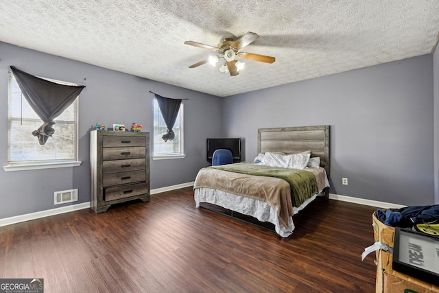 bedroom featuring a textured ceiling, ceiling fan, and dark wood-type flooring