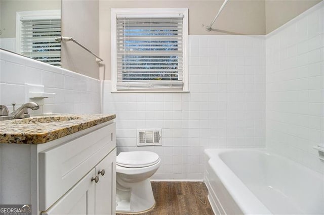 full bathroom with vanity, hardwood / wood-style flooring, and tile walls