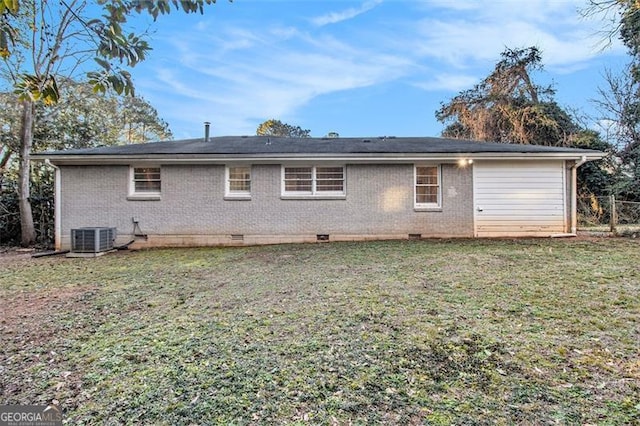 back of house with central AC unit and a lawn