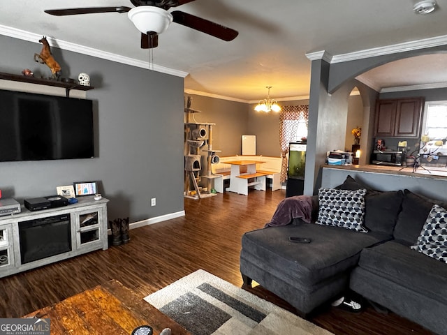 living room featuring ceiling fan with notable chandelier, dark hardwood / wood-style flooring, and crown molding