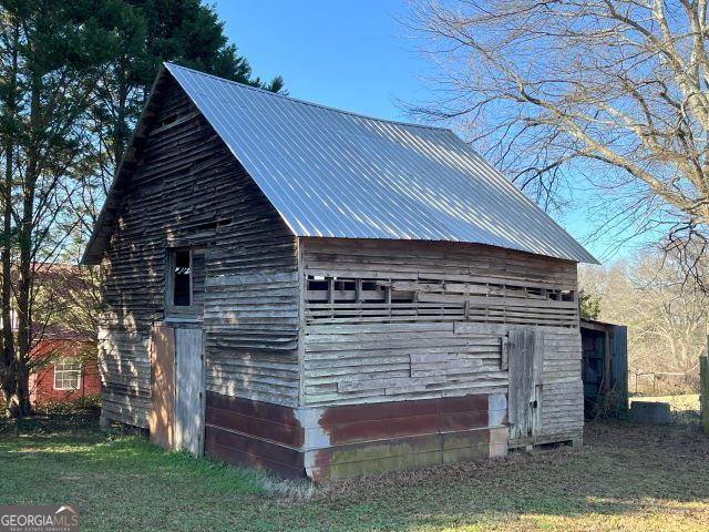 view of side of property with an outbuilding and a lawn