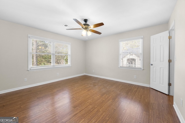 empty room featuring ceiling fan and dark wood-type flooring