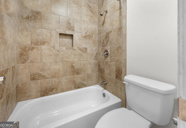 bathroom with tiled shower / bath combo and toilet