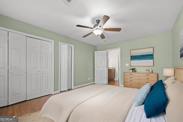 bedroom with ceiling fan, ensuite bathroom, and wood-type flooring