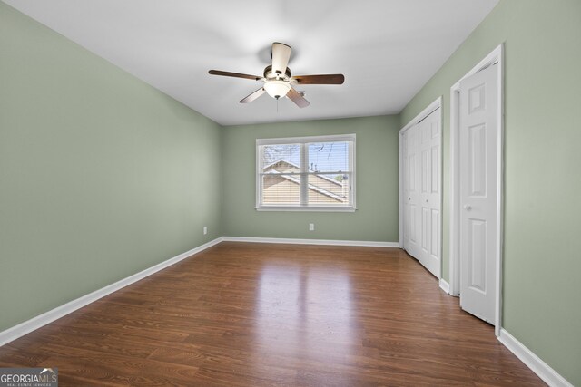 unfurnished bedroom with ceiling fan and dark hardwood / wood-style floors