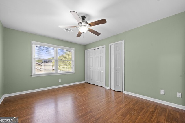 unfurnished bedroom featuring ceiling fan and dark hardwood / wood-style flooring