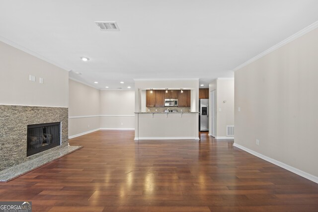 living room with dark hardwood / wood-style floors, crown molding, and a premium fireplace