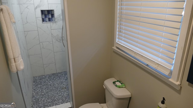 bathroom with toilet and tiled shower