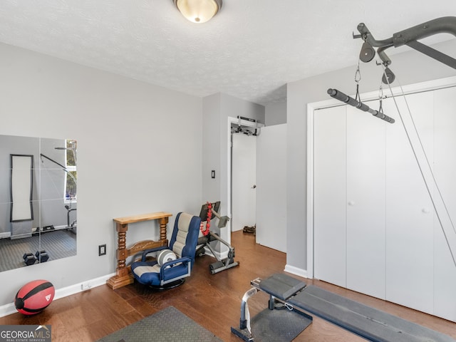 exercise room featuring a textured ceiling and hardwood / wood-style flooring