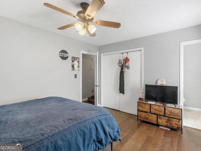 bedroom featuring hardwood / wood-style floors, ceiling fan, and a closet