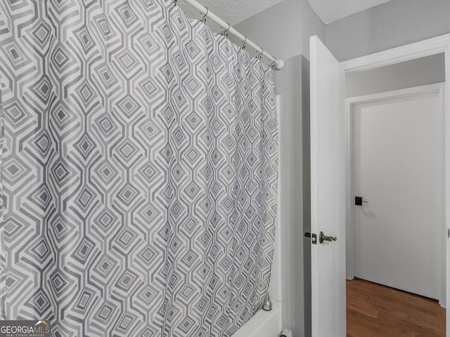 bathroom with hardwood / wood-style flooring and a shower with curtain