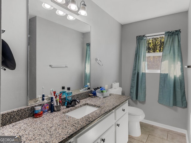 bathroom featuring tile patterned flooring, vanity, and toilet