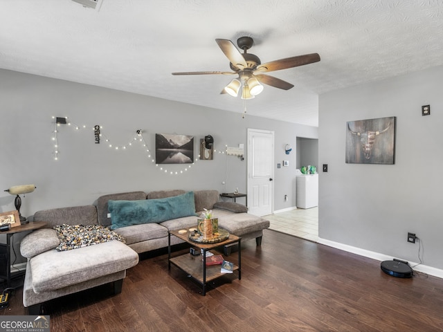 living room with a textured ceiling, hardwood / wood-style flooring, and ceiling fan