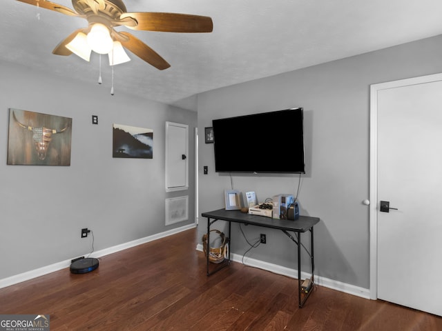 living room featuring ceiling fan and dark wood-type flooring