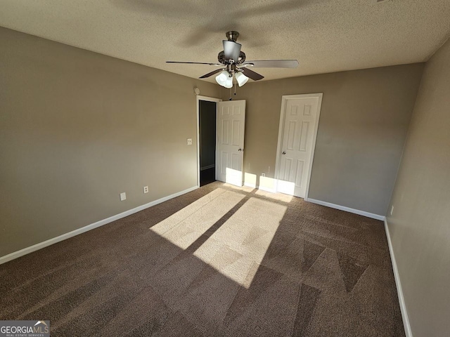 unfurnished bedroom with a textured ceiling, ceiling fan, and dark colored carpet