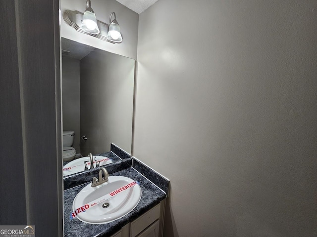 bathroom featuring toilet and vanity