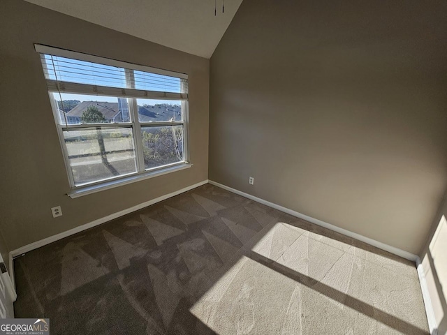 unfurnished room featuring vaulted ceiling, a mountain view, and dark colored carpet