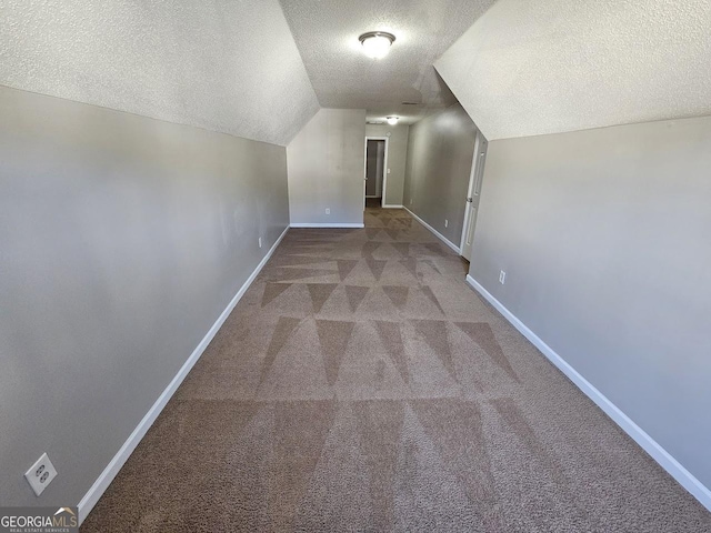 bonus room with a textured ceiling, lofted ceiling, and carpet flooring