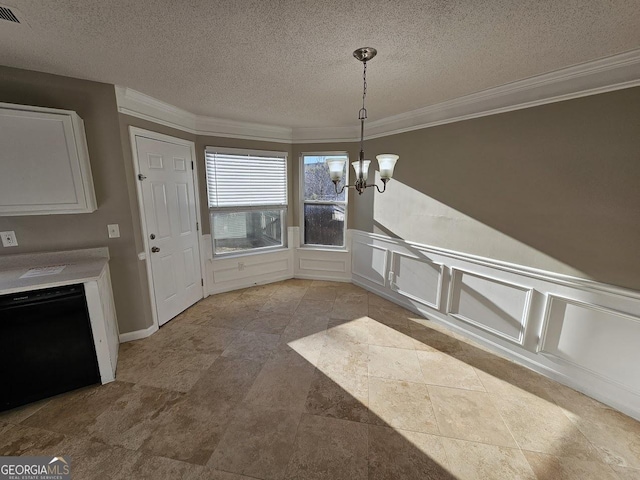 unfurnished dining area with a textured ceiling, crown molding, and a chandelier