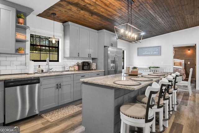 kitchen with wooden ceiling, stainless steel appliances, and decorative light fixtures