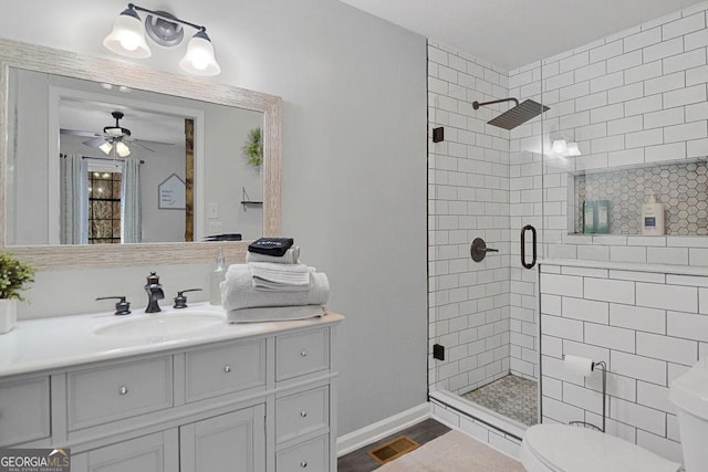 bathroom with ceiling fan, a shower with door, vanity, and toilet