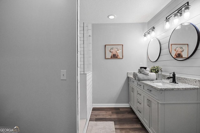 bathroom featuring wood-type flooring, vanity, and a textured ceiling