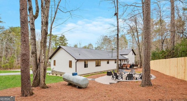 back of property featuring a patio and a fire pit