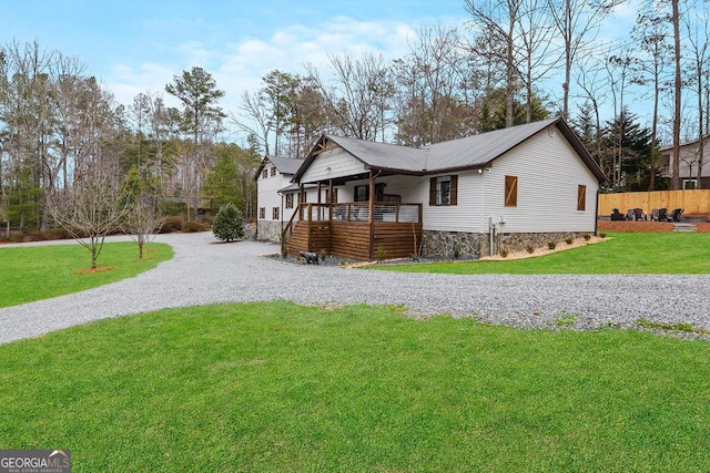 view of front of house with a front yard and a deck