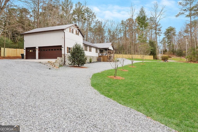 view of home's exterior with a yard, a deck, and a garage