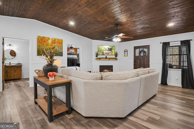 living room with hardwood / wood-style flooring, vaulted ceiling, ceiling fan, and wood ceiling