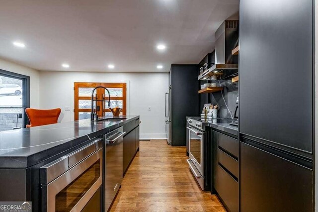 kitchen with tile countertops, a breakfast bar, hardwood / wood-style floors, high end fridge, and kitchen peninsula