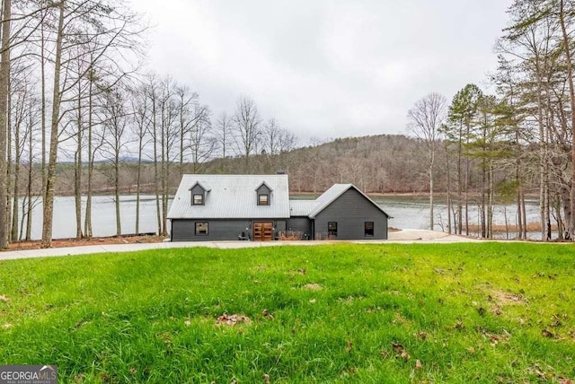 view of front facade with a water and mountain view and a front lawn