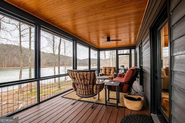 sunroom featuring a water view, a wealth of natural light, and wooden ceiling