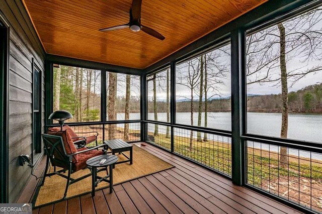 sunroom / solarium featuring a water view, ceiling fan, and wooden ceiling