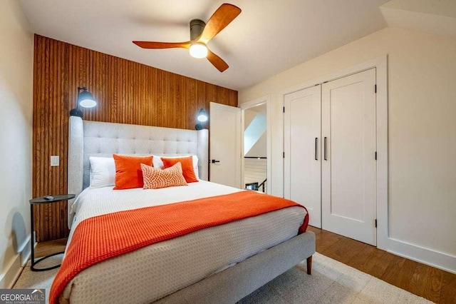 bedroom with a closet, hardwood / wood-style flooring, and ceiling fan