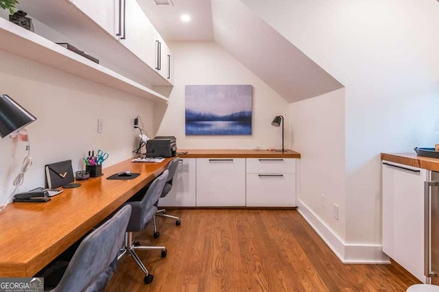 office area featuring light hardwood / wood-style floors, built in desk, and lofted ceiling