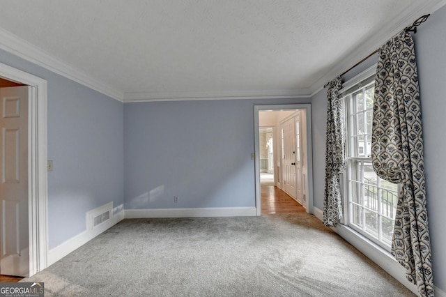 unfurnished room with carpet flooring, a textured ceiling, and crown molding