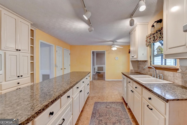 kitchen with white cabinetry, sink, tasteful backsplash, a textured ceiling, and track lighting