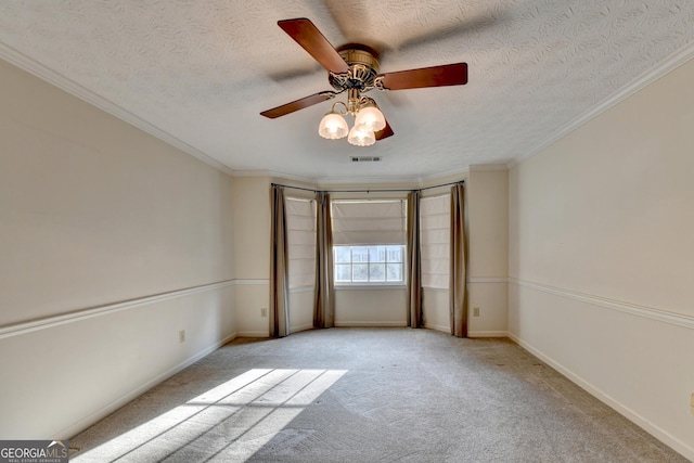 carpeted empty room with a textured ceiling, ceiling fan, and crown molding