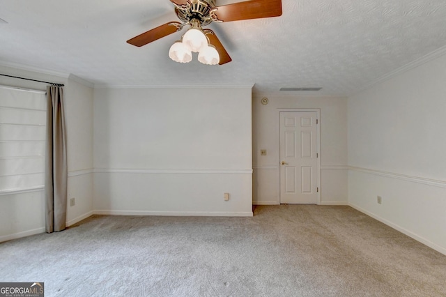 carpeted empty room featuring a textured ceiling, ceiling fan, and crown molding