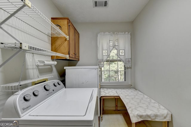 clothes washing area featuring cabinets and independent washer and dryer