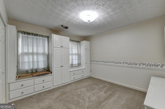 unfurnished bedroom with light carpet and a textured ceiling