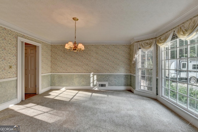 unfurnished dining area featuring a textured ceiling, a notable chandelier, carpet floors, and crown molding