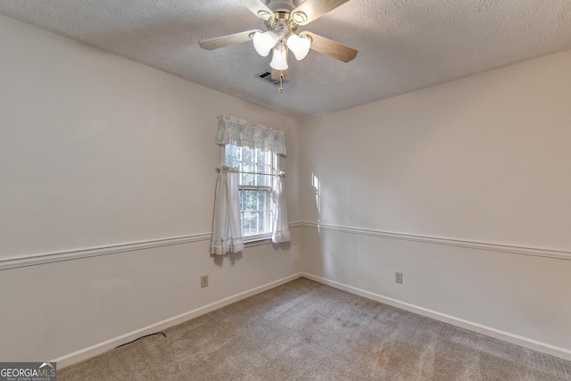 carpeted spare room with ceiling fan and a textured ceiling