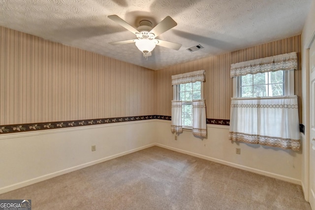 carpeted empty room featuring a textured ceiling and ceiling fan