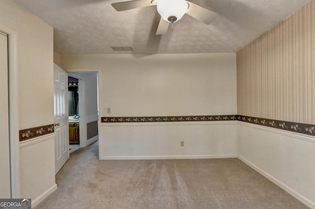 spare room with light carpet, a textured ceiling, and ceiling fan