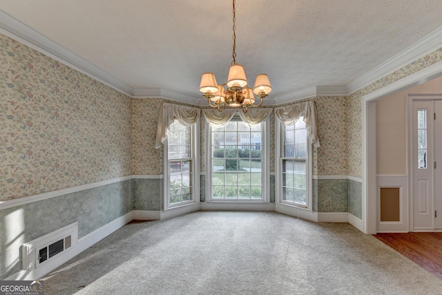 unfurnished dining area featuring ornamental molding, carpet floors, and a chandelier